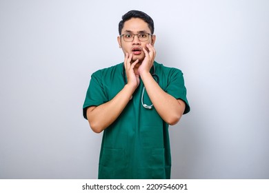 Impressed And Surprised Asian Male Nurse Or Doctor In Scrubs Drop Jaw And Stare At Camera Speechless, Looking Amazed Over White Background