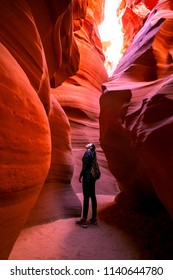 Impressed young woman looking up inside of the Antelope Canyon, Arizona, USA.