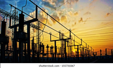 Impression network at transformer station in sunrise, high voltage up to yellow sky take with yellow tone, horizontal frame 