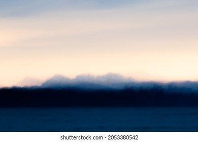 An impressionist photograph of the Cheam Mountain Range as seen from Boundary Bay British Columbia at Sunrise. Taken using the ICM (intentional camera movement) technique. - Shutterstock ID 2053380542