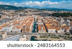 An impressive aerial shot of Trieste, Italy, featuring a majestic cruise ship docked at the port. This vibrant city, known for its rich history, stunning architecture, and bustling waterfront