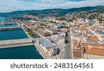 An impressive aerial shot of Trieste, Italy, featuring a majestic cruise ship docked at the port. This vibrant city, known for its rich history, stunning architecture, and bustling waterfront