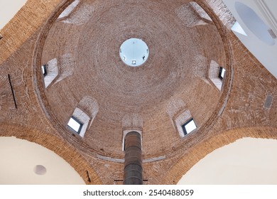 Impressive brick vault with windows and a lantern that let light into the interior. Below, the chimney of an industrial glass and crystal manufacturing furnace