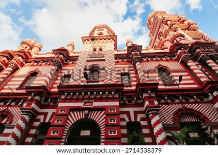Impressive façade of the iconic Jami‑Ul‑Alfar Mosque with its unique red and white design built in Indo-saracenic style by Tamil Muslim traders in 1909 in the Pettah area in Colombo,Sri Lanka