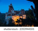 Impressive landscape with illuminated Bran Castle in evening dusk, Romania