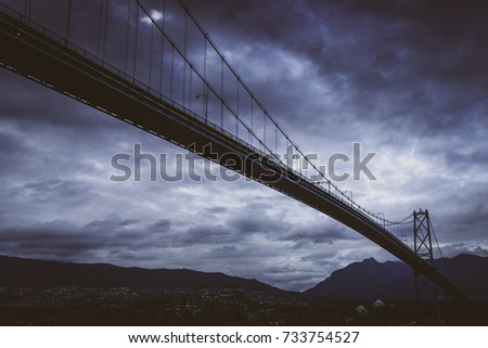 Impressive Lions Gate Bridge spanning across Burrard Inlet to Vancouver's Northshore on a cloudy evening, Vancouver, British Columbia