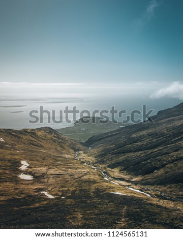 A big cloud hangs over a fjord