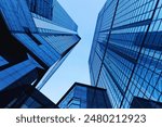 Impressive panoramic photo of skyscrapers against a bright blue sky. This urban scene showcases modern architecture including tall buildings and a sparkling city skyline. Perfect as a visual backdrop