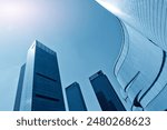Impressive panoramic photo of skyscrapers against a bright blue sky. This urban scene showcases modern architecture including tall buildings and a sparkling city skyline. Perfect as a visual backdrop