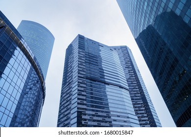 Impressive skyscrapers up to sky. Blue glass building from glass, modern architectural style. Apartments and offices in huge houses.