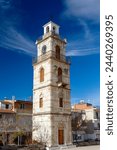 Impressive stone-built belfry with beautiful cloud stripes over an intensevily blue sky, in the picturesque village of Krokos, in Kozani region, Macedonia, Greece, Europe.