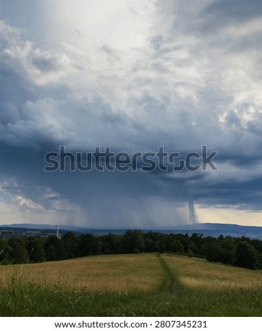 Impressive storm clouds with rain shafts over South Bohemian landscape and Klet mountain