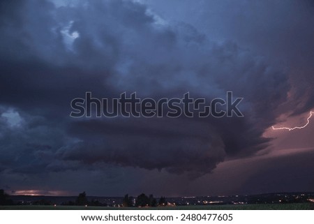 An impressive supercell thunderstorm with a powerful dramatic structure and high lightning intensity 
moves across the night sky over the eastern German city of Chemnitz in summer.