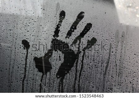 Imprint of a male hand on a car glass