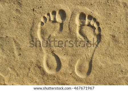 imprint of man's foot on the sand on the beach.