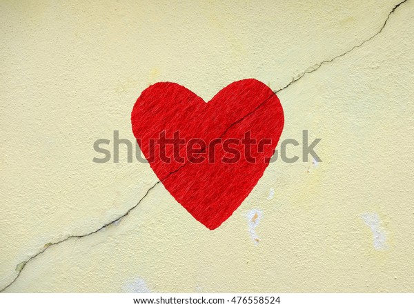 Imprint\
of a red fabric heart on a cracking mason\
wall.\
