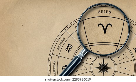 La impresión del signo zodiaco Aries en papel antiguo se amplía con una lente