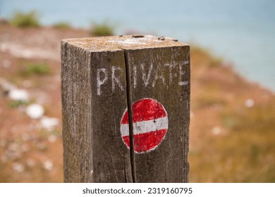 Improvided private no entry sign on a wooden fence post
