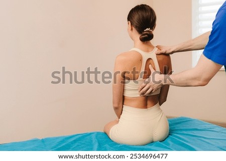 Improving back mobility in clinic. Doing osteopathy to reduce pain and muscle tension. Physiotherapist is treating upper back pain for female patient