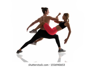 Improving flexibility through pilates training. Couple of athletes training together isolated on white. Athletic training. Physical training activity and sport. Fitness. - Shutterstock ID 1556940653