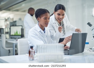 Improving lives one collaboration at a time. Shot of two young scientists using a laptop in a laboratory.