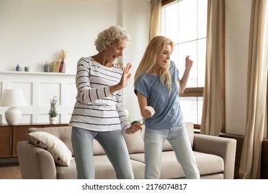 Improvised party. Elder and younger women best friends, aged active granny and grown grandchild girl spending time together dancing relaxing at home celebrating housewarming, purchasing new apartment - Shutterstock ID 2176074817