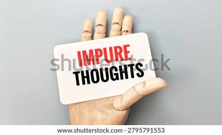 Impure Thoughts Text on White Card Held by Wooden Hand Representing Mental Reflection Self Awareness and Personal Values. 