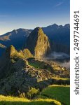 The Inca citadel of Machu Picchu, white misty clouds and Huayna Picchu mountain in the background, Peru.