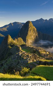 The Inca citadel of Machu Picchu, white misty clouds and Huayna Picchu mountain in the background, Peru.