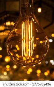 incandescent bulb in the shape of a ball with a soft warm light and a background with blurred lights