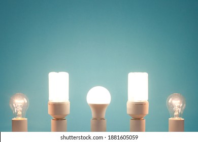 Incandescent light bulb, compact fluorescent lamp, LED lamp in one line on a blue background. All lamps are on. - Powered by Shutterstock