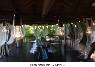 Incandescent Light Bulb. Decorations Evening Dinner With A Garland Of A Plurality Of Electric Lamps.