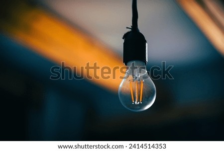 Incandescent light bulb with a medium-sized E27 hanging on wire.