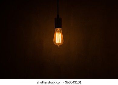 Incandescent light bulb with plaster wall as a background - Powered by Shutterstock