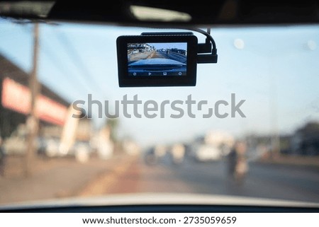 In-car dash camera capturing city traffic during daytime, highlighting driving safety, accident evidence, insurance claims, smart vehicle technology.