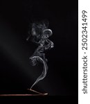 incense stick smokes on a wooden stand on a dark background. Aromatherapy, Smoke while burning incense. smoke for prayers and meditation. prayer to buddha. incense for relaxation and yoga