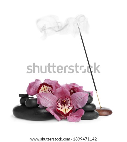 Incense stick smoldering in holder near orchid flowers and spa stones on white background