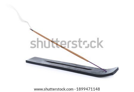 Incense stick smoldering in holder on white background