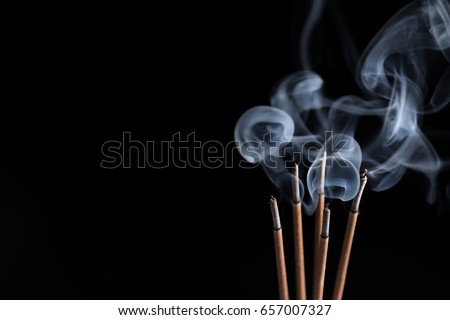 Incense sticks and incense stick smoke on black backgrond with white backlit