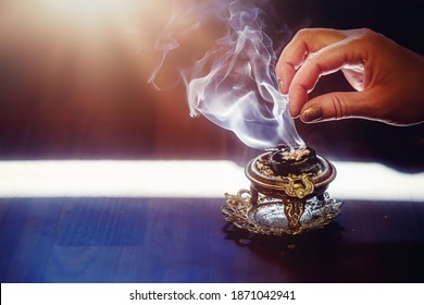 incense in a woman hand, incense smoke on a black background. - Powered by Shutterstock