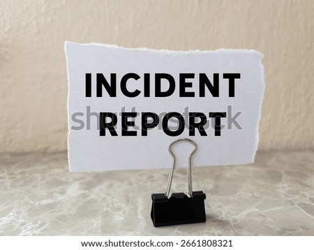 Incident report message written on ripped torn white paper piece on wall background. Conceptual incident report symbol. Copy space.