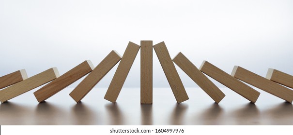 Incidental beneficiary, illustrated by standing tile (lucky survivor or beneficiary) in-between collision of two domino effects - Shutterstock ID 1604997976