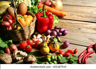 Include fresh organic vegetables basket on wooden floor with copy space still life