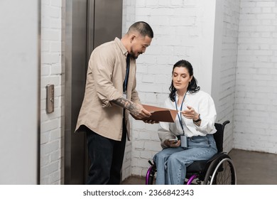inclusion, asian businessman discussing startup plan with disabled woman near office elevators