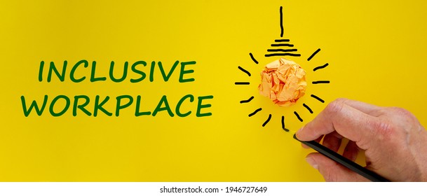 Inclusive Workplace Symbol. Businessman Writing Words 'Inclusive Workplace', Yellow Background. Light Bulb Icon. Business, Diversity And Inclusive Workplace Concept. Copy Space.