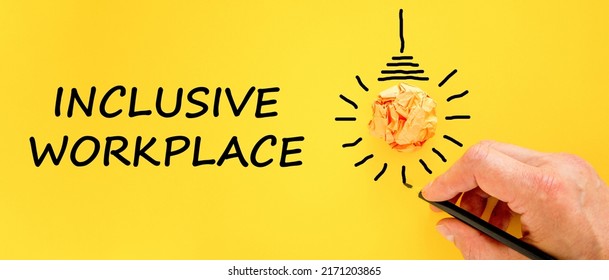 Inclusive Workplace Symbol. Businessman Writing Words 'Inclusive Workplace', Yellow Background. Light Bulb Icon. Business, Diversity And Inclusive Workplace Concept. Copy Space.