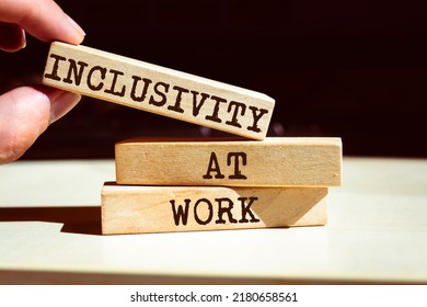 Inclusivity At Work Symbol. Businessman Hand. Wooden Blocks With Words 'Inclusivity At Work'.