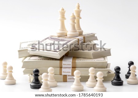 Income inequality, class struggle in capitalism and social issue concept theme with large group of chess pawns representing the poor separated from the wealthy who are sitting on a pile of money
