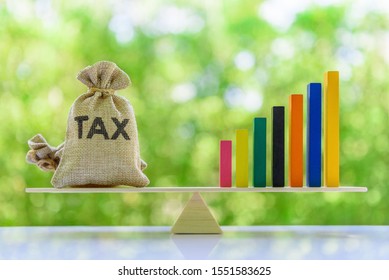 Income Tax Collection Growth, Tax Payer Increasing Concept : Tax Bags, Rising Bar Graph On A Basic Balance Scale, Depict Fiscal Tax Revenue Gain And Meet Target After Economic Policy And Stimulus Plan