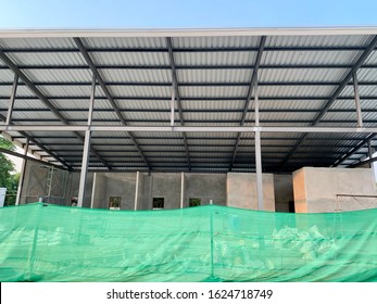 Incomplete Building Construction With Green Mesh Fence